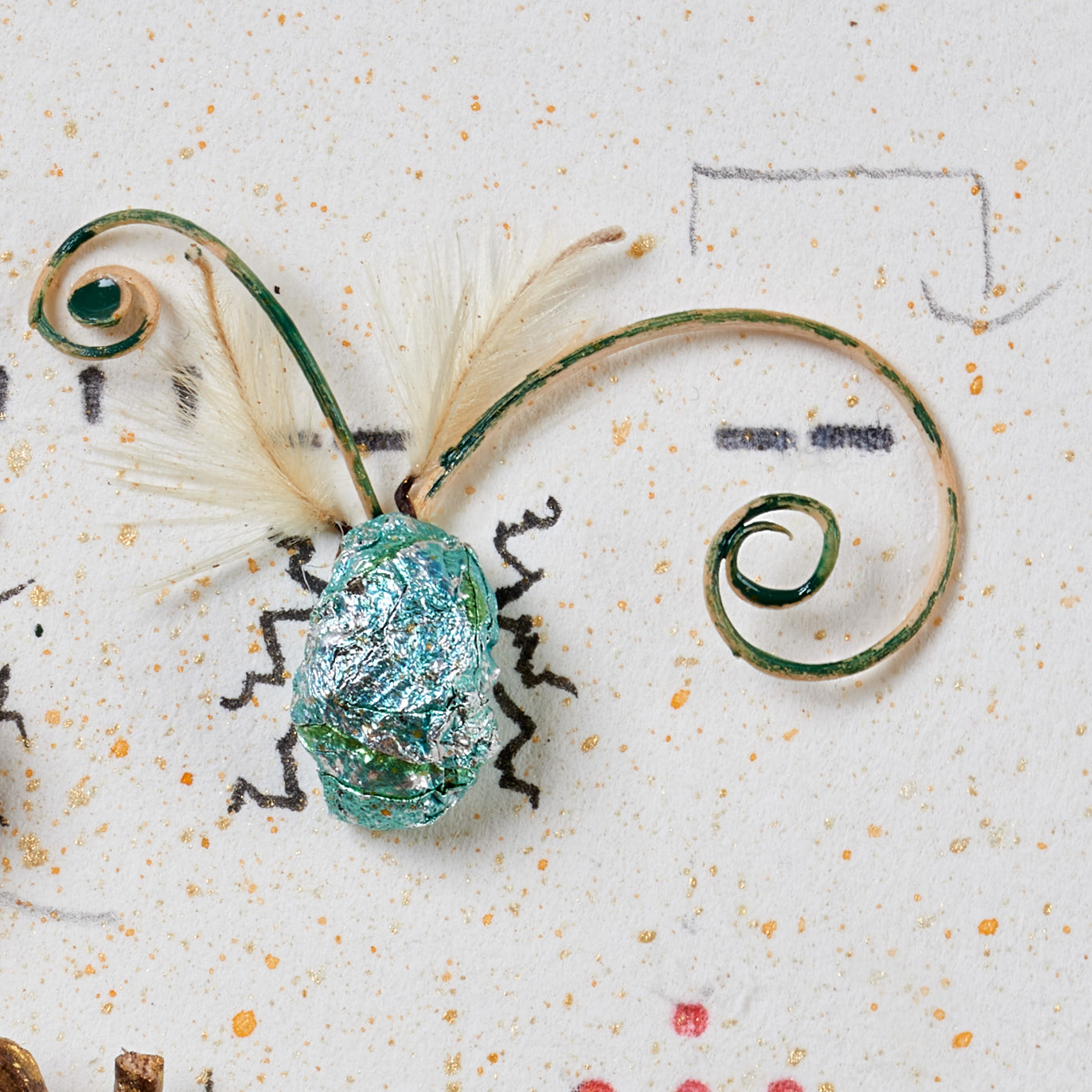 Collage of found objects, in which a beetle is created from chocolate paper and plant parts