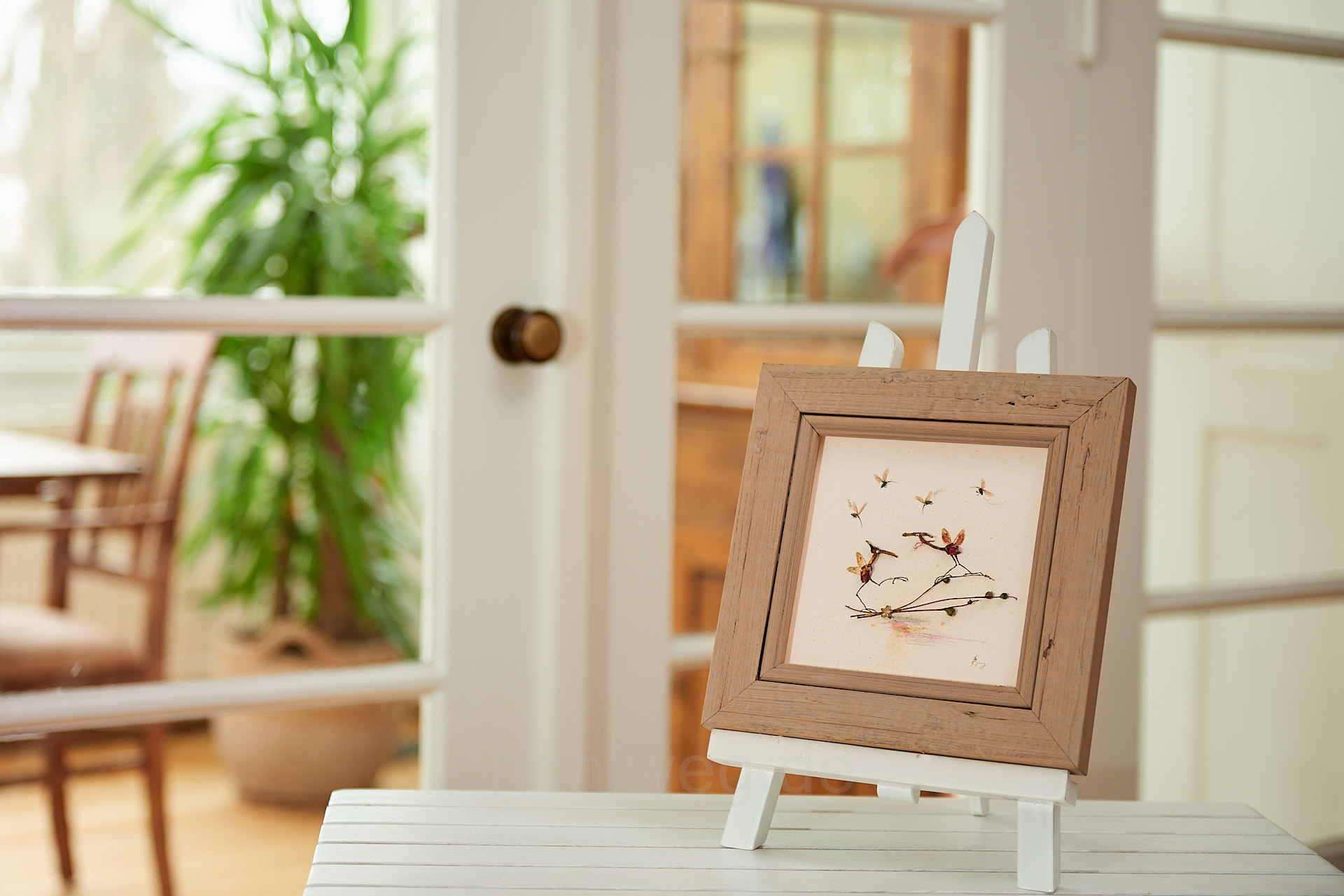 Die Collage "Perlentaucher" im Raum mit Staffelei auf einem Tisch präsentiert