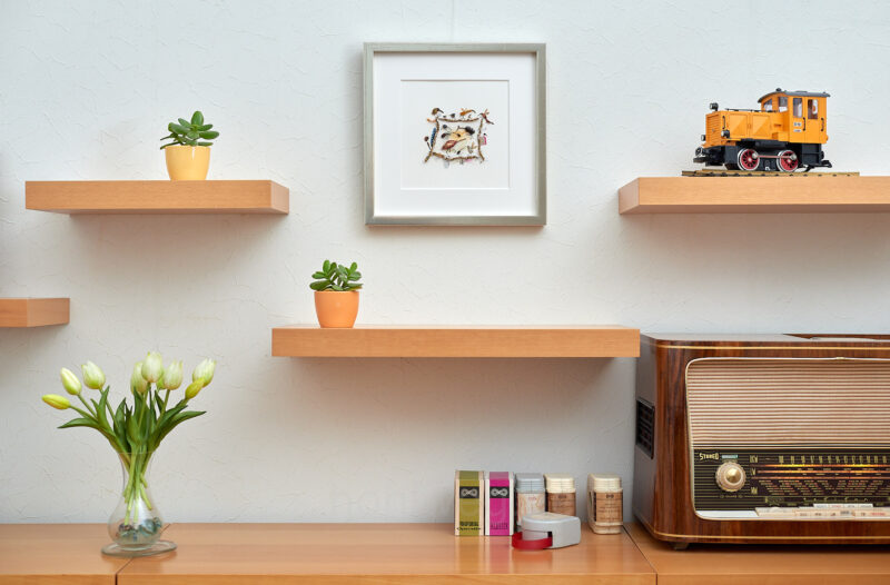 A framed miniature collage titled “The Digitization of Nature?” on a shelf in a bright, cozy setting.
