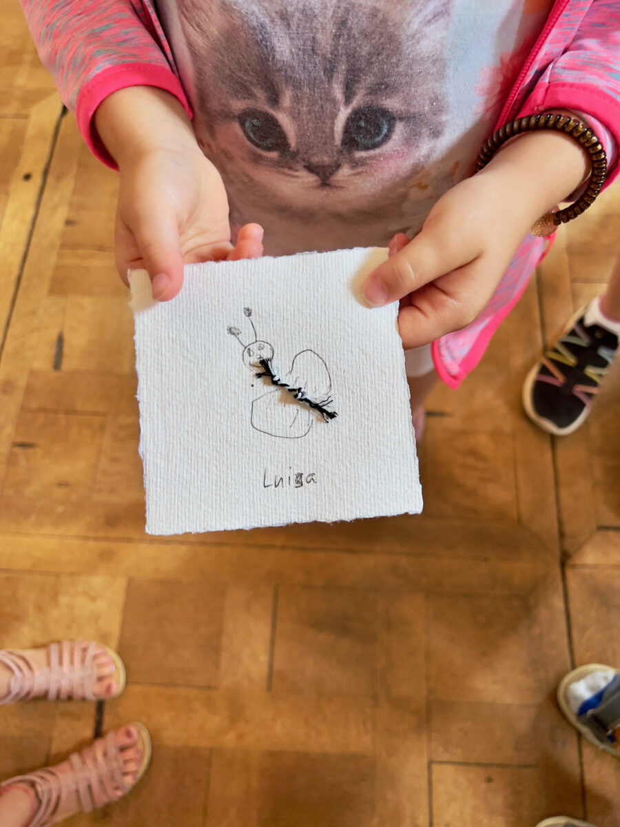 Kinderhände halten eine Collage aus Fundstücken in die Kamera