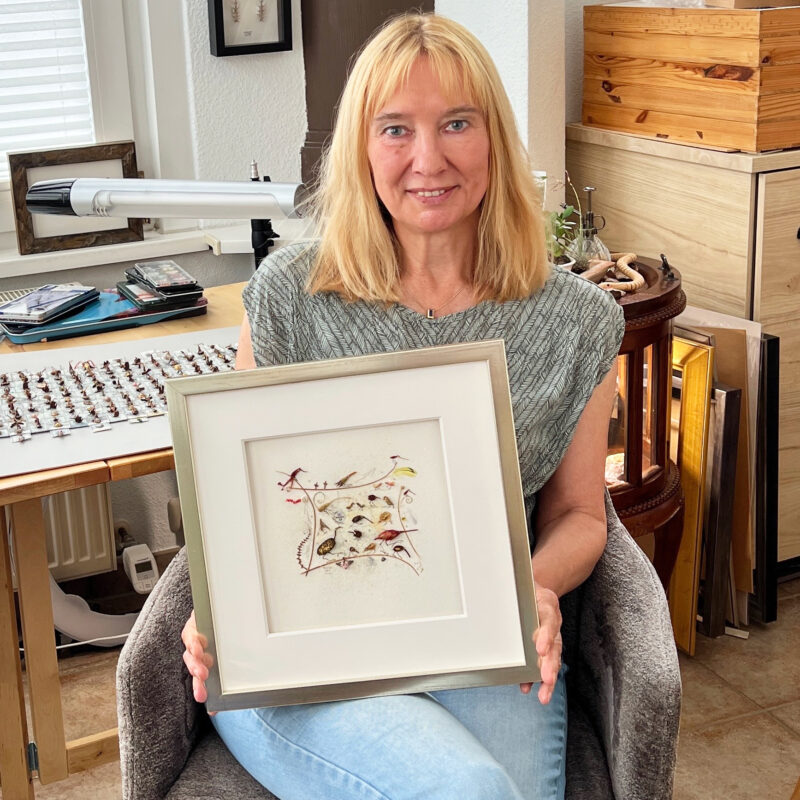 Magdalena Hohlweg is exhibiting her framed assemblage titled "The Navel of the World" in her studio.