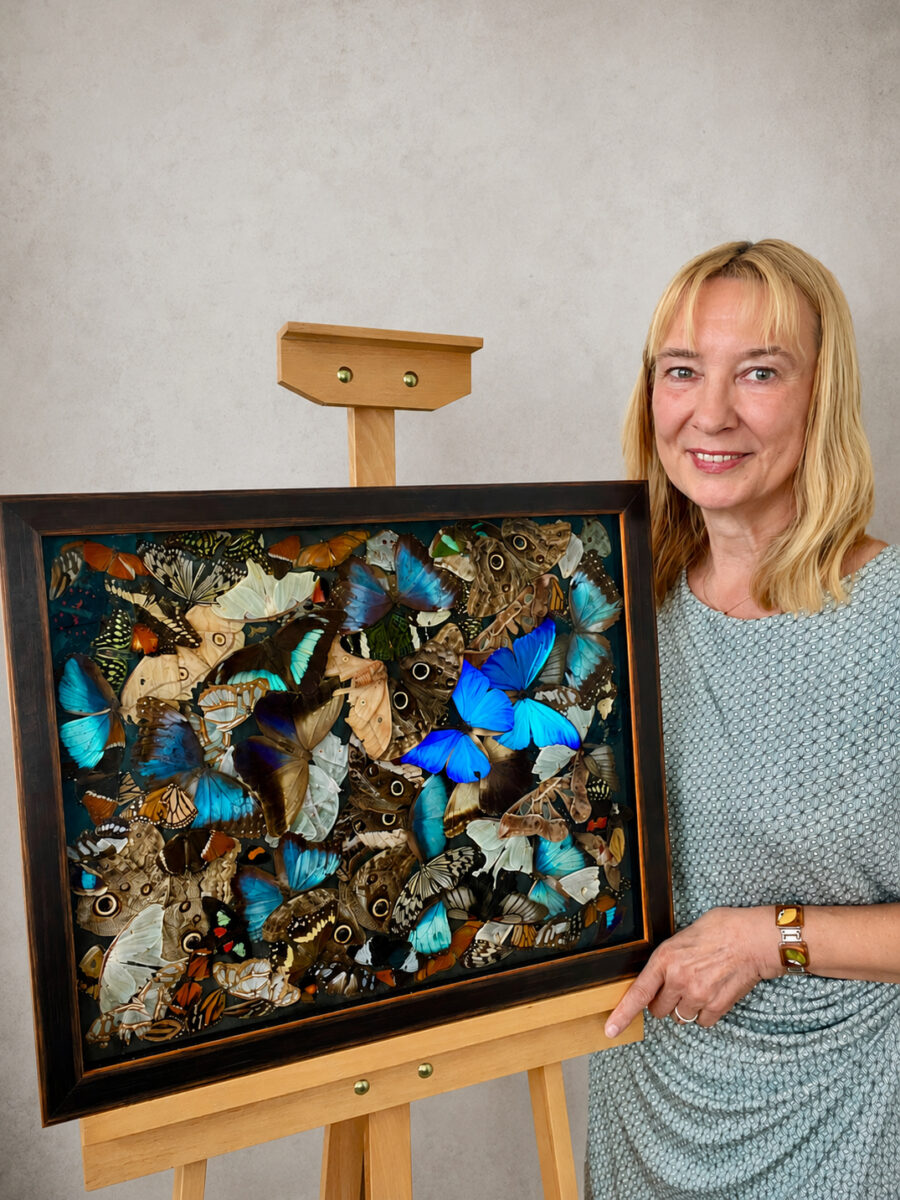 Magdalena Hohlweg presents her large-scale assemblage of butterflies, titled “Forever and Ever,” standing on an easel in front of a wall